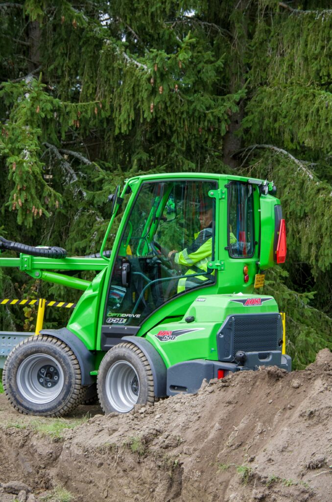 Green wheel loader operated by worker at construction site in Lepaa, Finland.